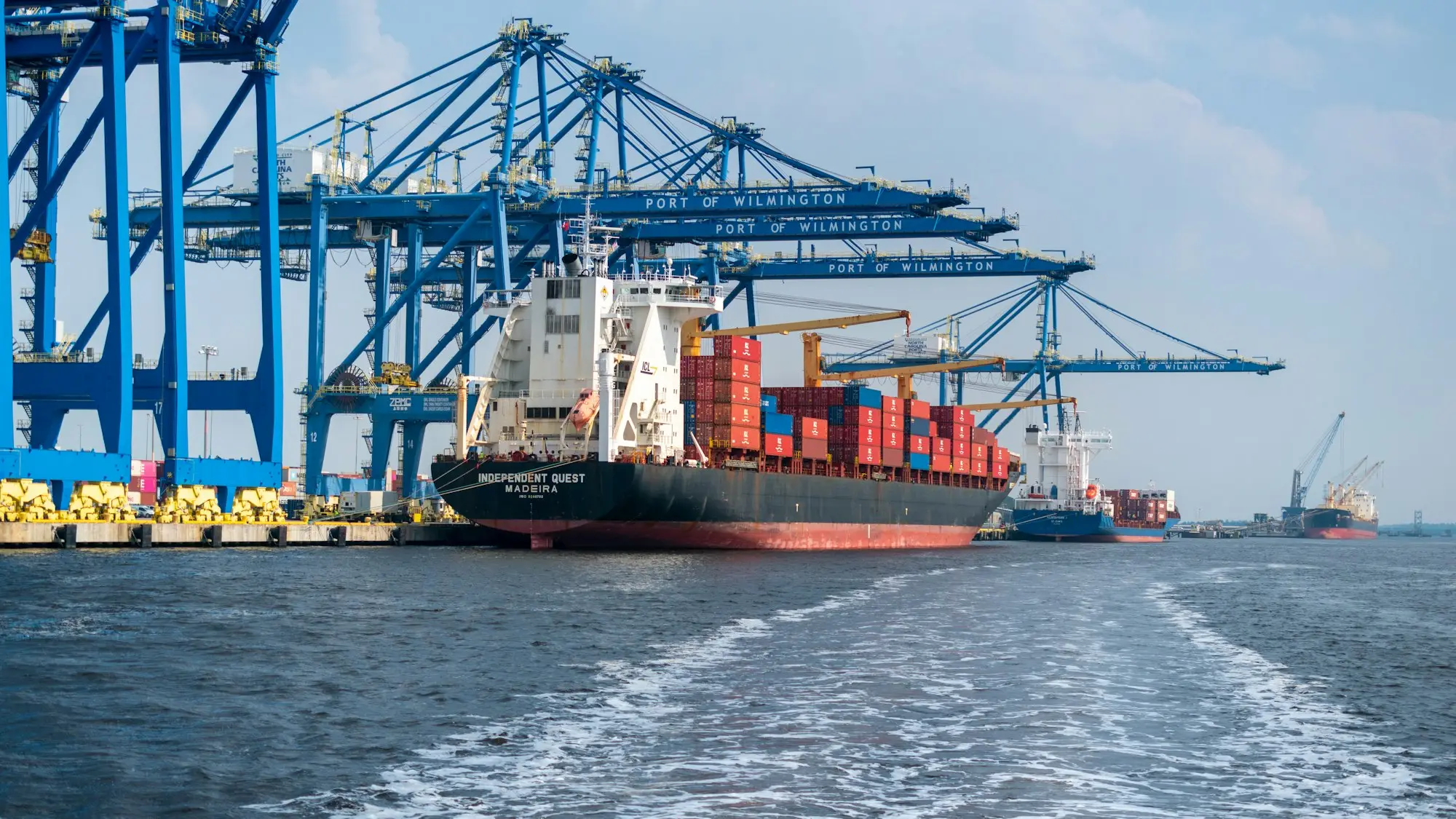 Cargo ship with a port crane behind it