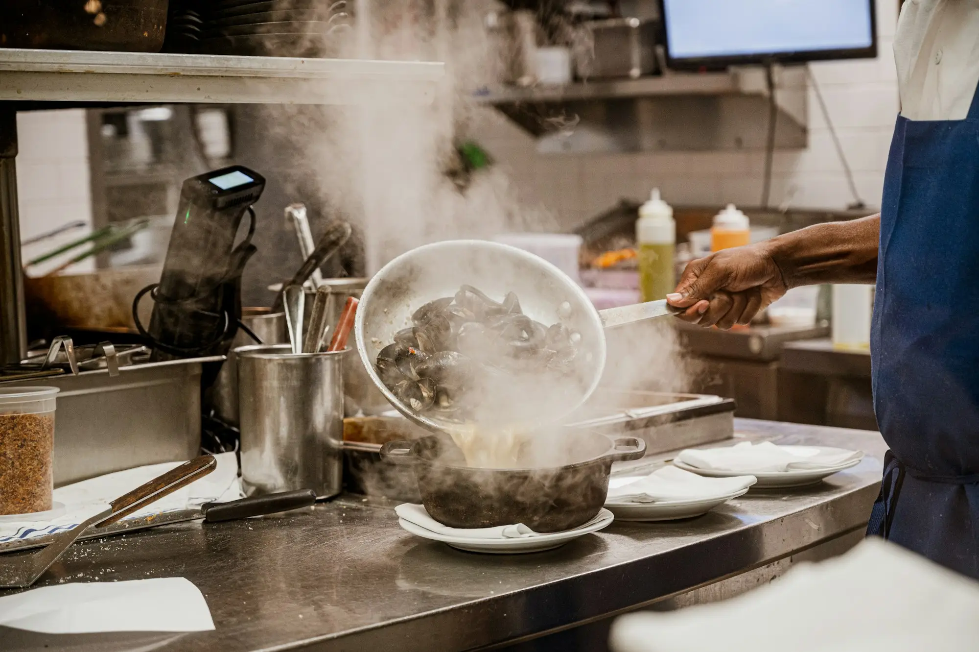 Cook working at a stove in a commercial kitchen