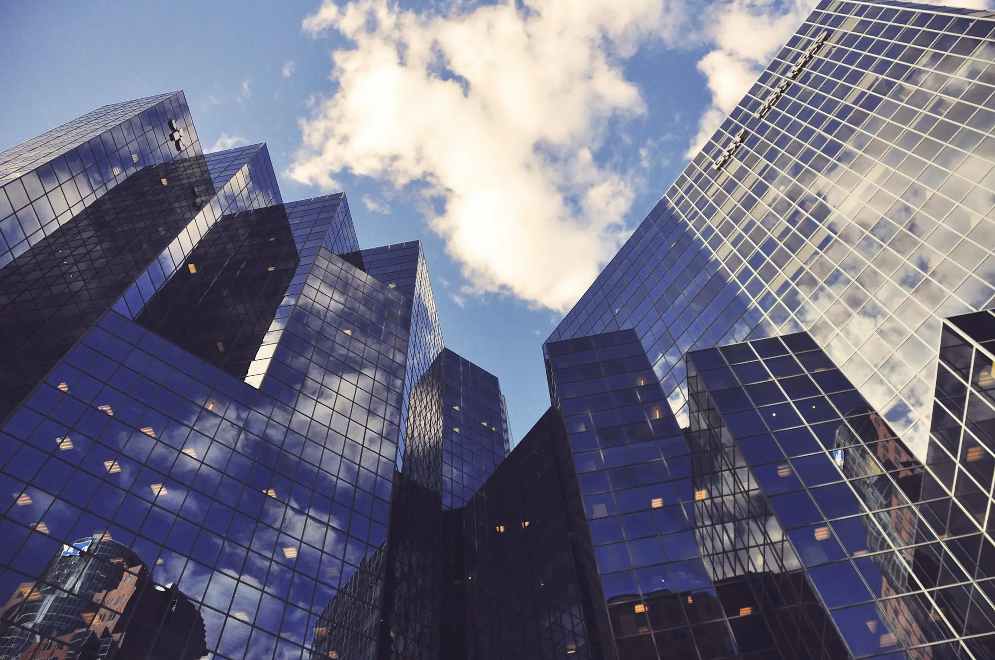 Looking up at a glass curtain-wall office tower