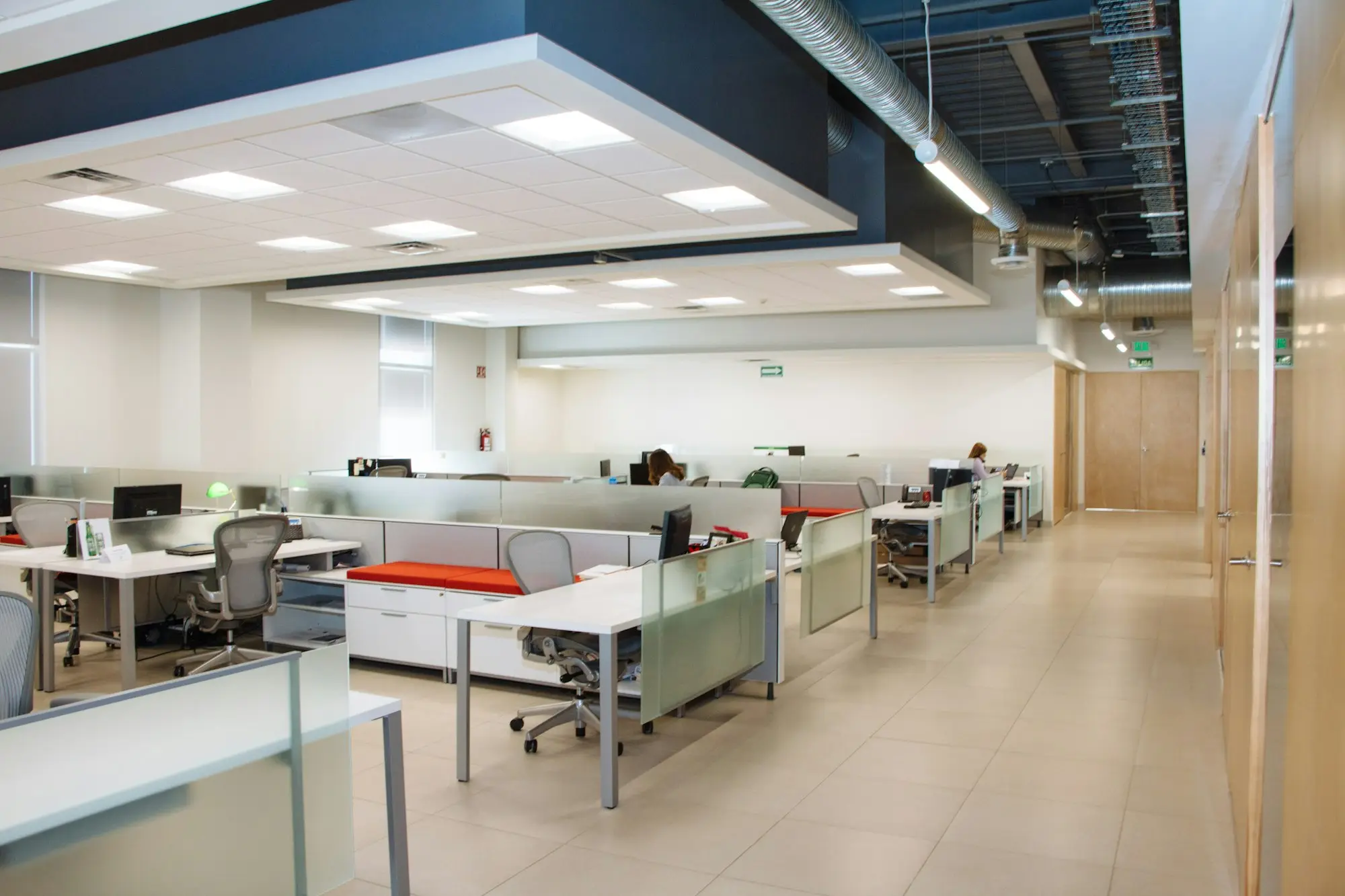 Open plan office with rows of desks and frosted glass