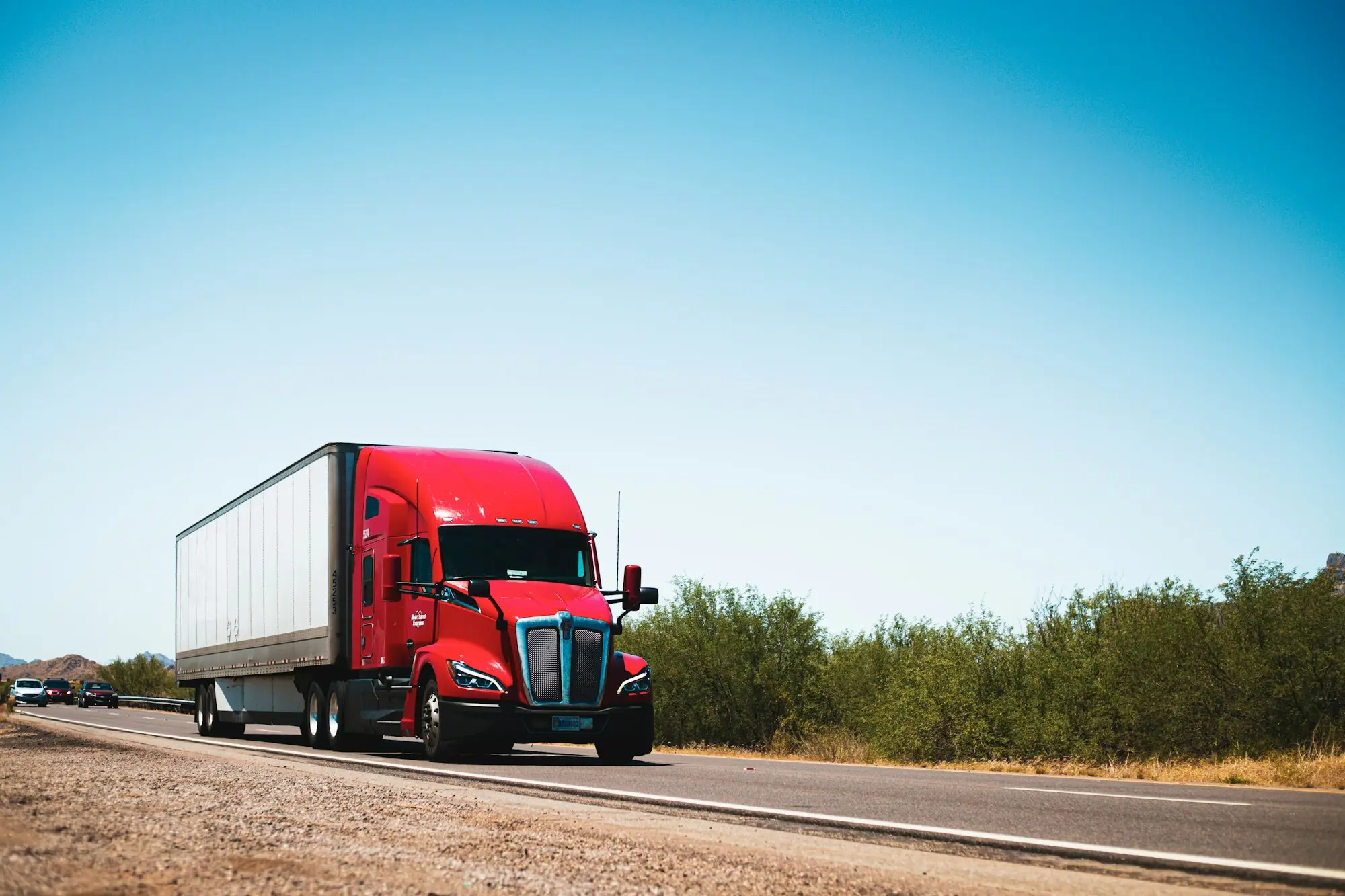 Red prime mover driving down a country road