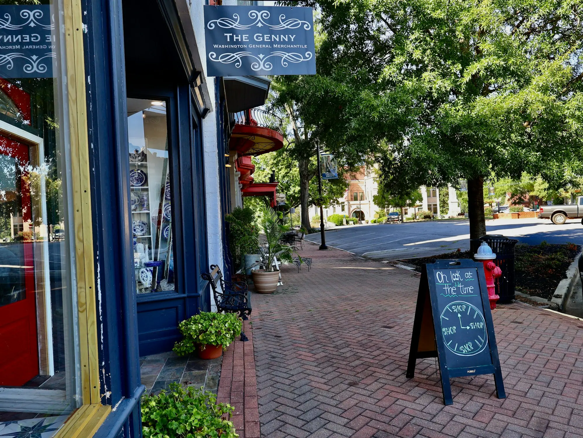 Small shop with a chalkboard sign on a brick footpath